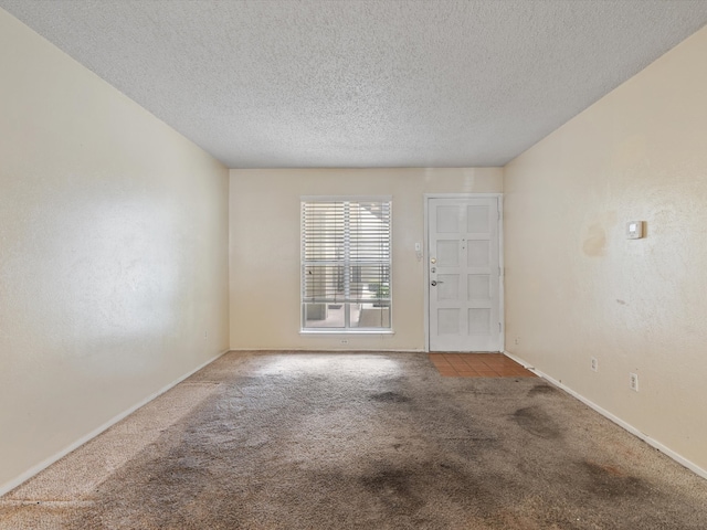 unfurnished room featuring light carpet and a textured ceiling