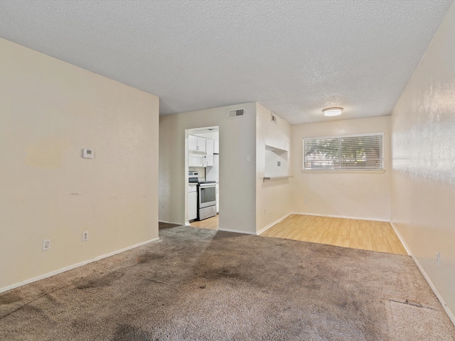 carpeted empty room with a textured ceiling