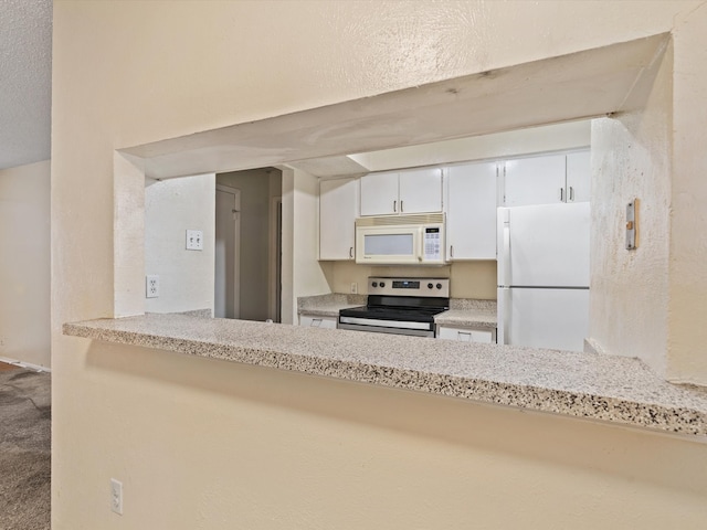 kitchen with white cabinetry, carpet floors, and white appliances