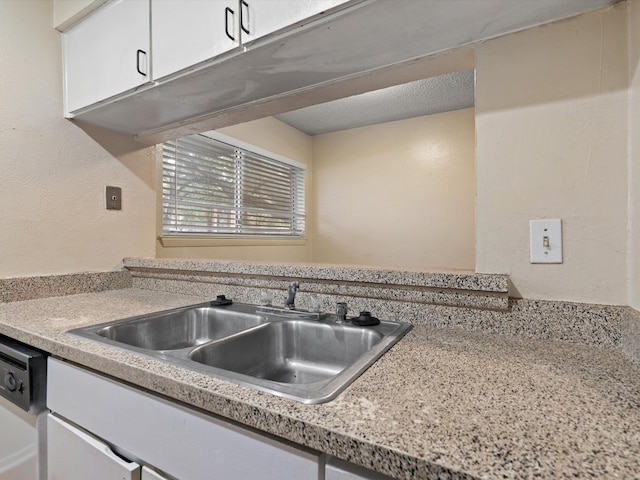 kitchen featuring white cabinets, dishwasher, sink, and a textured ceiling