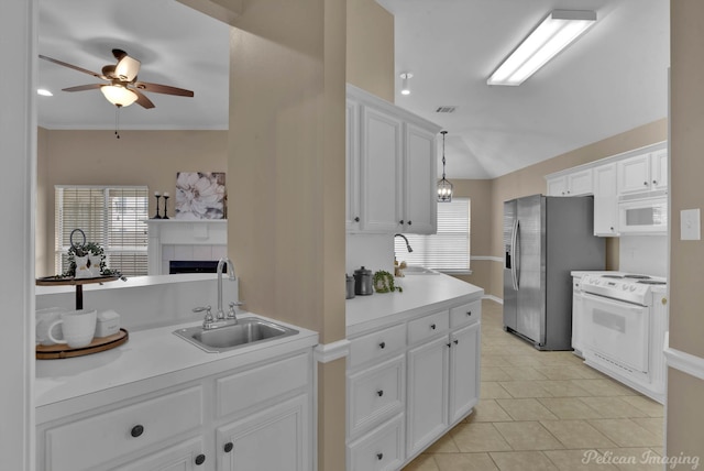 kitchen with white appliances, white cabinetry, sink, and hanging light fixtures