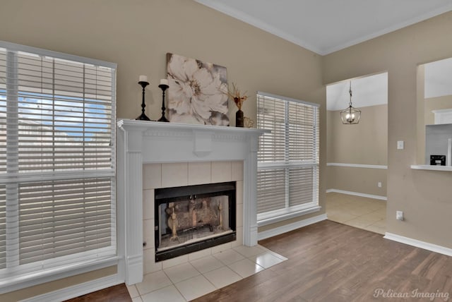 unfurnished living room featuring hardwood / wood-style floors, crown molding, and a tile fireplace