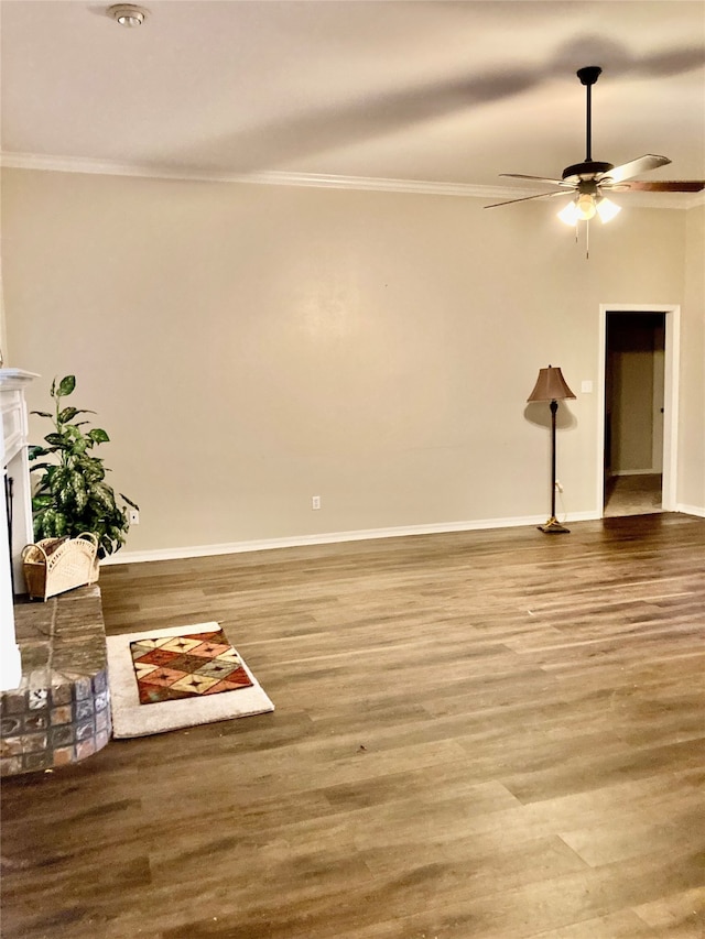 spare room featuring crown molding, a fireplace, ceiling fan, and hardwood / wood-style floors