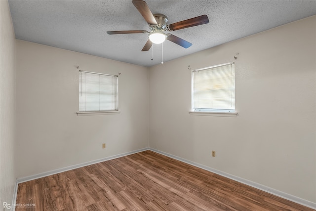 empty room with a textured ceiling, hardwood / wood-style flooring, and ceiling fan