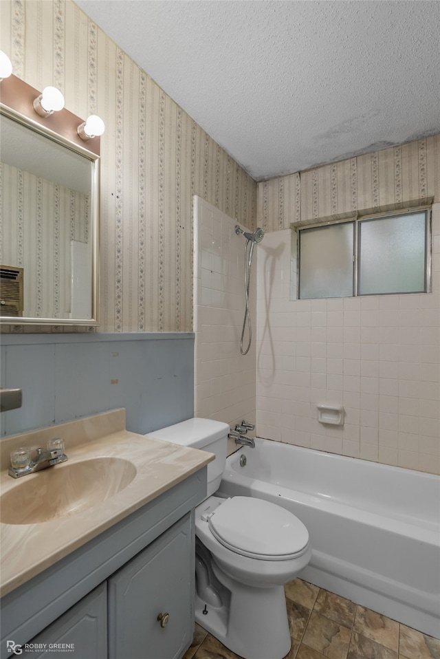 full bathroom featuring toilet, tiled shower / bath, a textured ceiling, and vanity