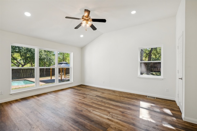 spare room featuring ceiling fan, lofted ceiling, a wealth of natural light, and dark hardwood / wood-style floors