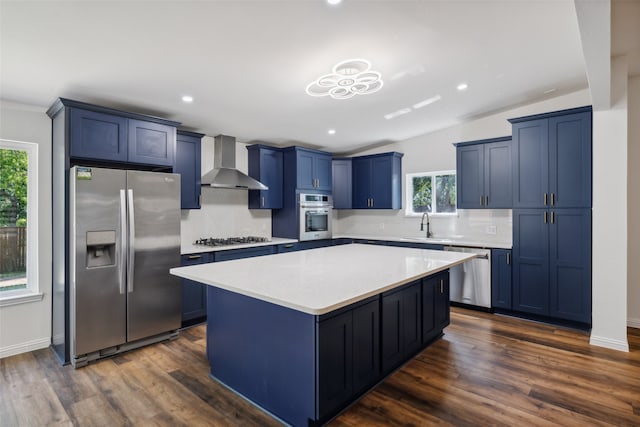 kitchen featuring wall chimney exhaust hood, dark wood-type flooring, appliances with stainless steel finishes, and a wealth of natural light