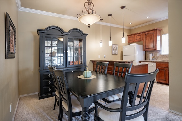 carpeted dining area featuring ornamental molding