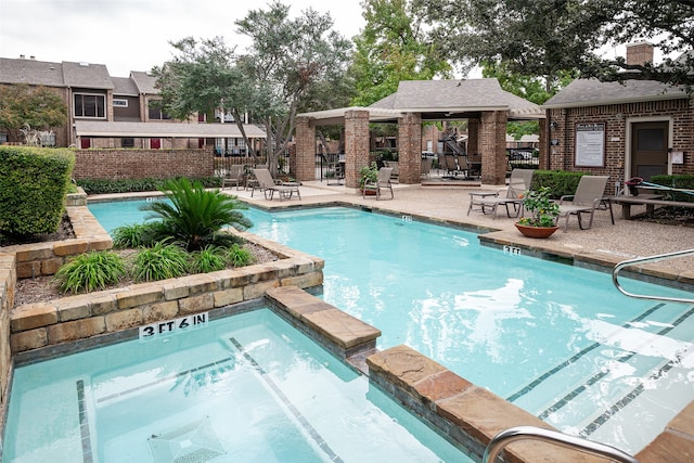 view of swimming pool featuring a community hot tub and a patio