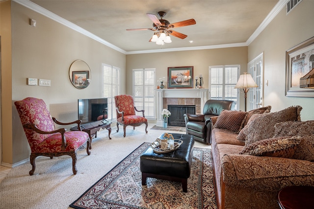 living room with ornamental molding, light colored carpet, a tile fireplace, and ceiling fan