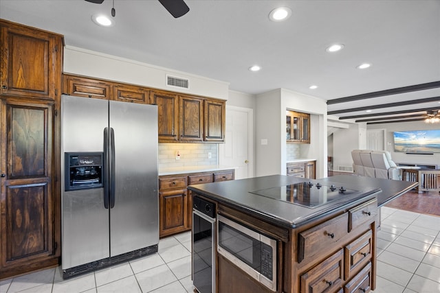 kitchen with backsplash, stainless steel appliances, light tile patterned floors, and a kitchen island