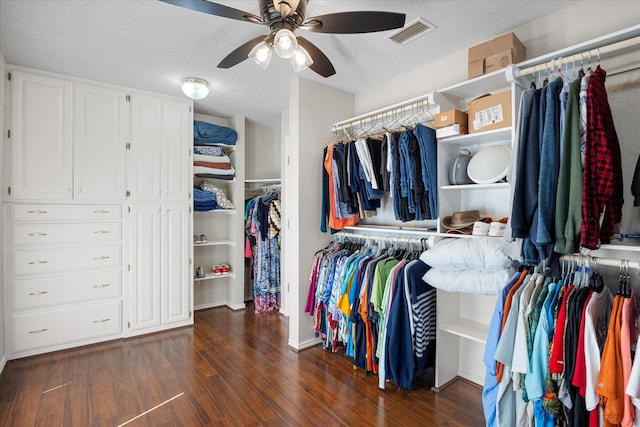 walk in closet with dark wood-type flooring and ceiling fan