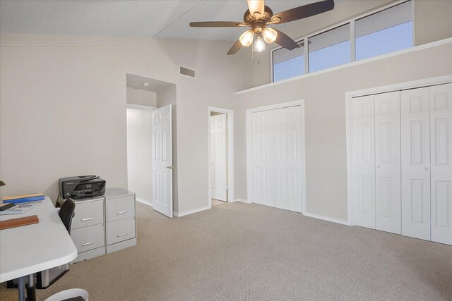 carpeted office featuring ceiling fan, high vaulted ceiling, and a textured ceiling