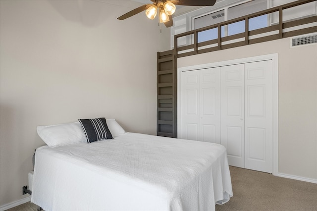 carpeted bedroom with a high ceiling, a closet, and ceiling fan