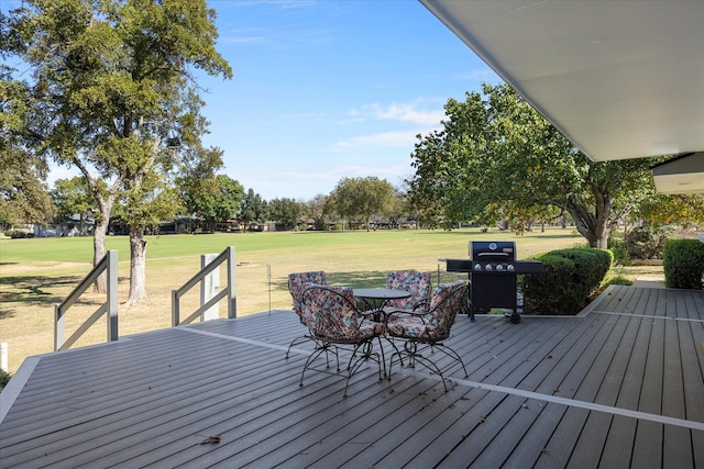 wooden deck featuring a grill and a lawn