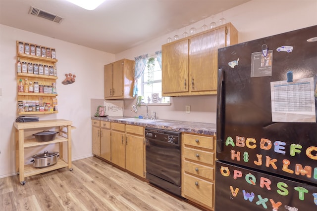 kitchen featuring sink, black appliances, and light hardwood / wood-style flooring