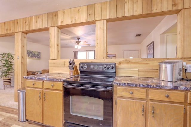 6495 Waterworks Rd, Midlothian, TX 76065 - kitchen with black range with electric stovetop, dark countertops, a ceiling fan, and light wood-type flooring