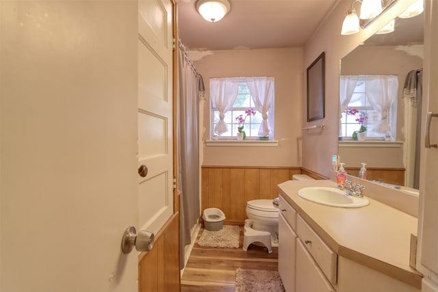 bathroom with vanity, toilet, wood-type flooring, and wooden walls