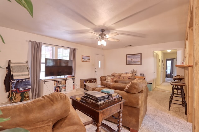 living room featuring light colored carpet and ceiling fan