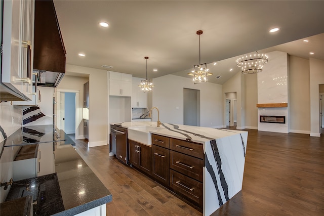 kitchen with an island with sink, dark brown cabinets, white cabinetry, stainless steel dishwasher, and dark wood-type flooring