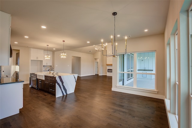 kitchen featuring dark brown cabinets, a center island with sink, hanging light fixtures, white cabinetry, and dark wood-type flooring