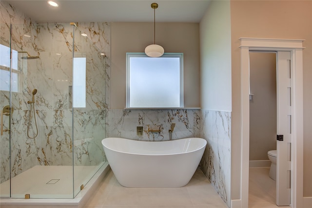 bathroom featuring toilet, tile walls, tile patterned floors, and separate shower and tub