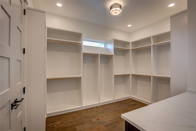 walk in closet with dark wood-type flooring