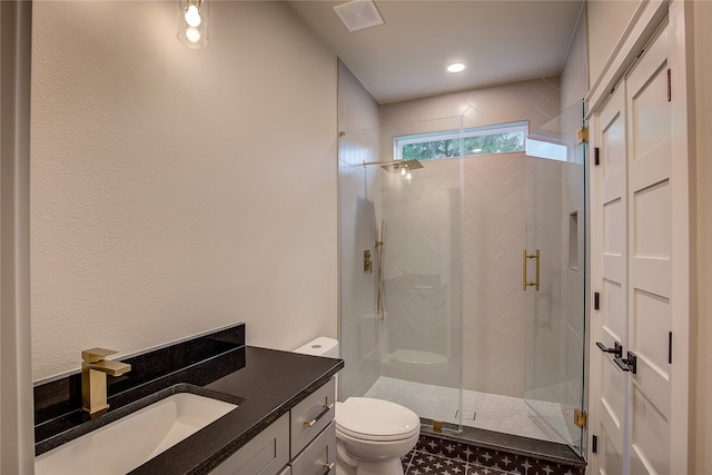 bathroom with toilet, a shower with shower door, and vanity