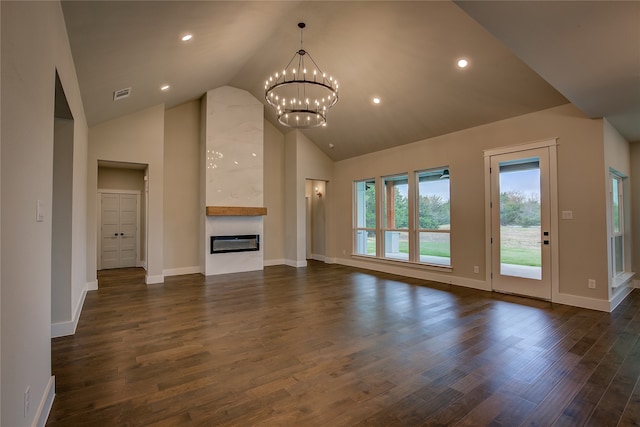 unfurnished living room with high vaulted ceiling, an inviting chandelier, and dark hardwood / wood-style floors