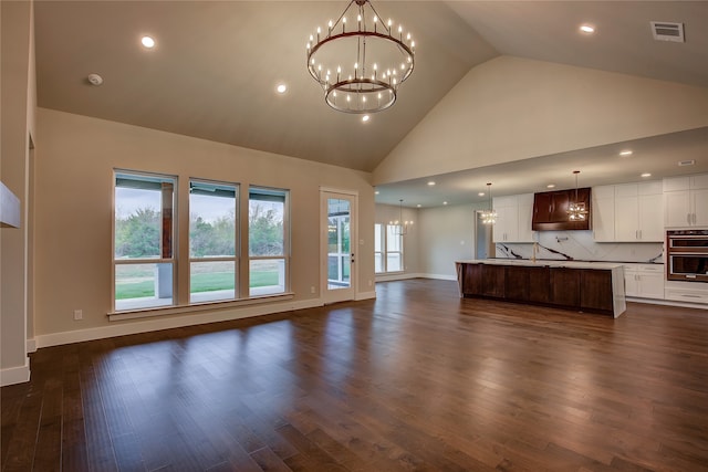 unfurnished living room featuring dark wood-type flooring and high vaulted ceiling