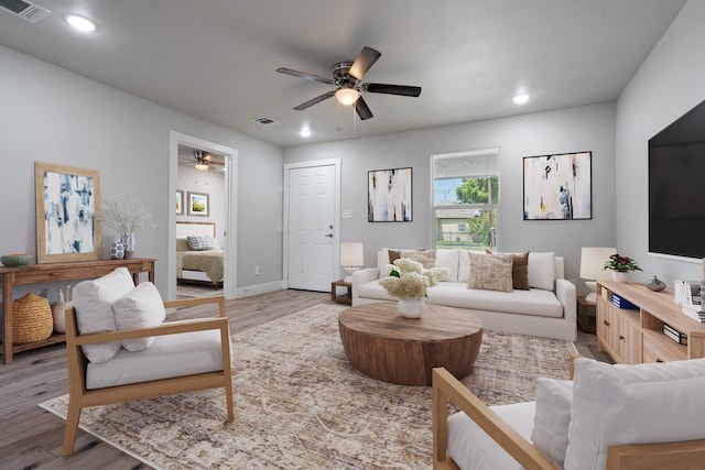 living room with ceiling fan and light hardwood / wood-style flooring