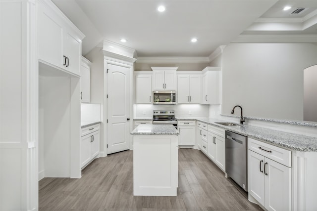 kitchen featuring kitchen peninsula, sink, stainless steel appliances, and light hardwood / wood-style flooring