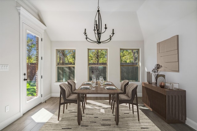 sunroom / solarium featuring an inviting chandelier, vaulted ceiling, and a healthy amount of sunlight