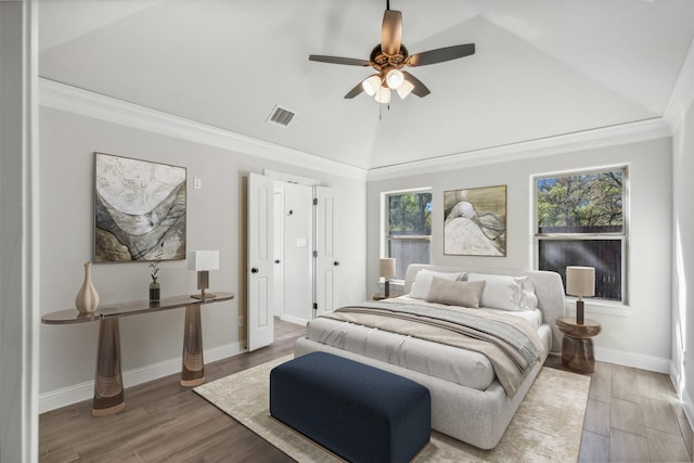 bedroom with hardwood / wood-style flooring, ceiling fan, ornamental molding, and vaulted ceiling