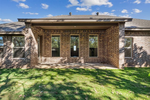 rear view of property with a lawn and a patio