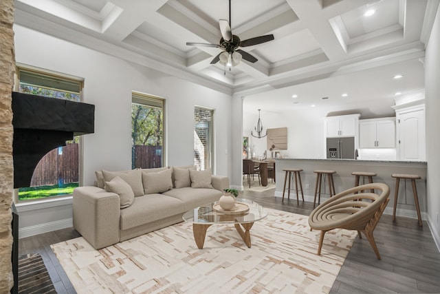 living room featuring ornamental molding, coffered ceiling, ceiling fan, beamed ceiling, and light hardwood / wood-style floors