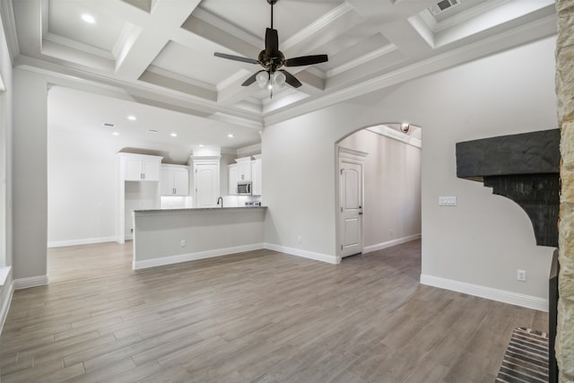 unfurnished living room with coffered ceiling, ceiling fan, ornamental molding, and light hardwood / wood-style flooring