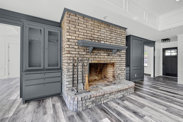 living room with crown molding, hardwood / wood-style flooring, and a fireplace