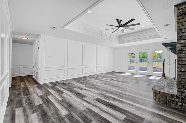 unfurnished living room with french doors, a textured ceiling, hardwood / wood-style flooring, and ceiling fan