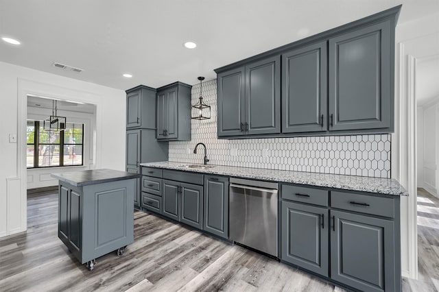 kitchen with wood-type flooring, a center island, stainless steel dishwasher, and hanging light fixtures