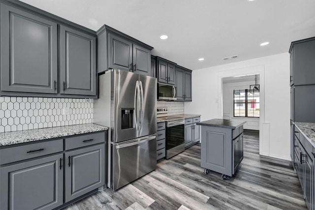 608 N Ave, Whitesboro, TX 76273 - kitchen with stainless steel appliances, wood finished floors, backsplash, a kitchen island, and recessed lighting