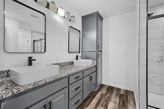 608 N Ave, Whitesboro, TX 76273 - full bath with wood finished floors, double vanity, a shower, and baseboards
