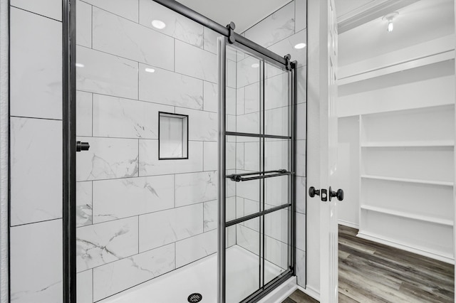 bathroom featuring an enclosed shower and wood-type flooring