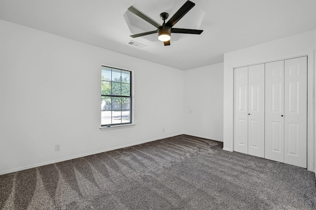 unfurnished bedroom with a closet, ceiling fan, and dark carpet