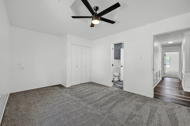 unfurnished bedroom featuring connected bathroom, dark hardwood / wood-style floors, a closet, and ceiling fan