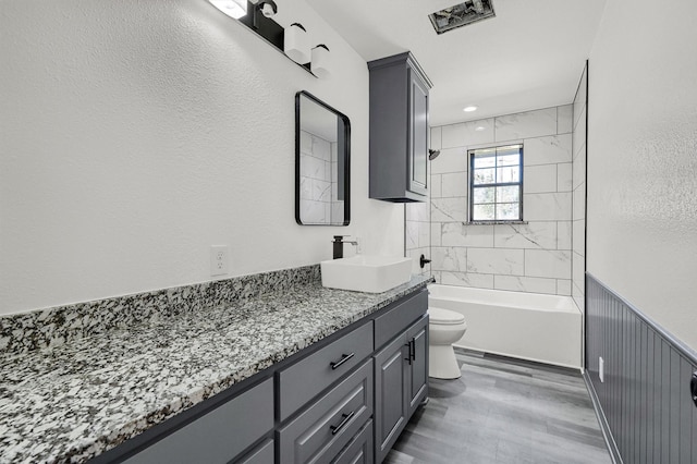 608 N Ave, Whitesboro, TX 76273 - bathroom with vanity, toilet, wood finished floors,  shower combination, and a wainscoted wall