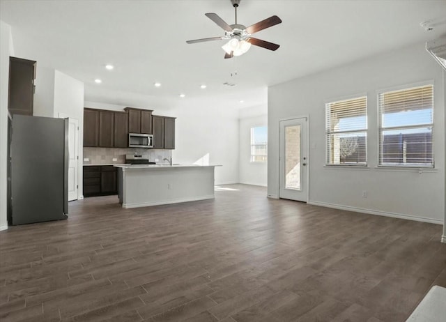 unfurnished living room with ceiling fan and dark hardwood / wood-style flooring