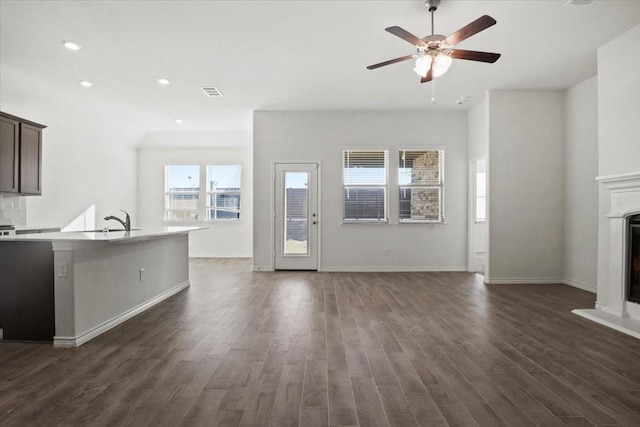 unfurnished living room featuring dark hardwood / wood-style flooring, sink, and ceiling fan