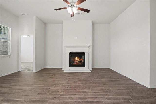 unfurnished living room with ceiling fan and dark hardwood / wood-style flooring