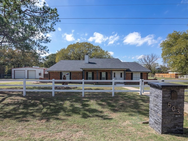 view of front of home with a garage, an outbuilding, and a front yard